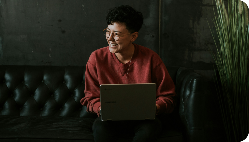 person sitting on a couch with their laptop